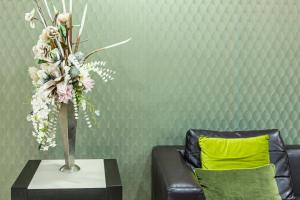Hotel Premiere في مارينا دي فاركاتورو: مزهرية من الزهور على طاولة بجوار أريكة
