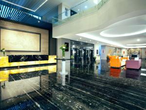 um lobby de um hotel com amarelo e azul em Platinum Hotel & Convention Hall Balikpapan em Balikpapan