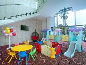 a room with a playground with a table and chairs at Platinum Hotel & Convention Hall Balikpapan in Balikpapan