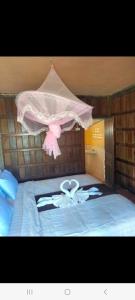 a bed with a pink teddy bear on top of it at Riverside Bungalow Don Det in Don Det
