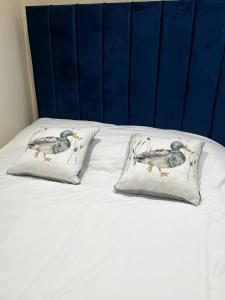 dos almohadas con pájaros en la cama en Flat in London en Londres