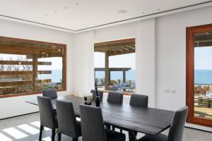 a dining room with a wooden table and chairs at The Cliff House וילה בבית ינאי קו ראשון לים in Bet Yannay