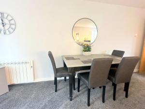 a dining room table with chairs and a mirror at Superb 2 bed 2 bathroom free parking in Derby