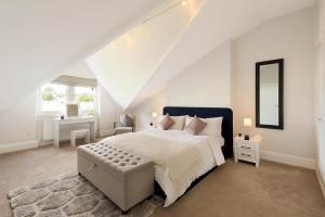 a white bedroom with a large bed and a mirror at Lovely Central Apartment with Park Views in London