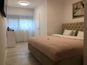 Un dormitorio con una cama grande y una ventana en Poseidon Residence, en Bucarest