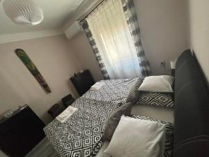 - une petite chambre avec 2 lits et une fenêtre dans l'établissement Estina House, à Balatonboglár