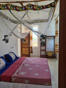 Un dormitorio con una cama grande con dosel. en Five Seasons Zanzibar opposite Mnemba island Hotel, en Makunge