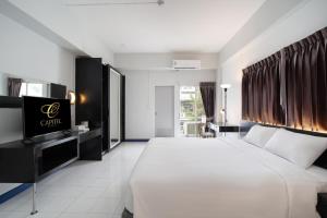 a hotel room with a large bed and a television at Capitel Rama 4 in Bangkok