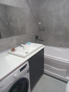 uma casa de banho com um lavatório e uma máquina de lavar roupa em Karavan Saray house em Türkistan