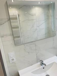 a white bathroom with a sink and a mirror at Jolie T3 à Colomiers in Colomiers