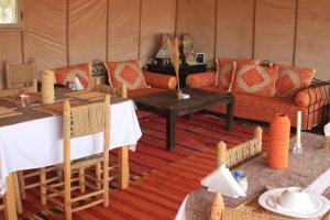 a living room with a couch and a table at Shooting Stars Camp in Merzouga