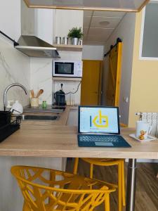 a laptop computer sitting on a wooden table in a kitchen at Work Room - kasasbenas in Benasque