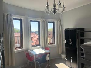 a room with a desk and two chairs and windows at City Hostel Bergen in Bergen