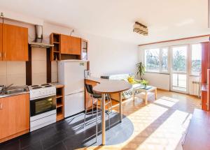 a kitchen with white appliances and a table in a room at Fat Kaz Apartment in Wrocław