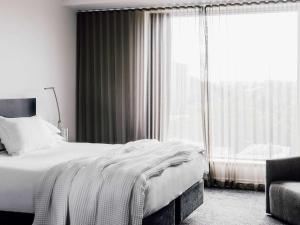 a bedroom with a bed and a large window at The Como Melbourne in Melbourne