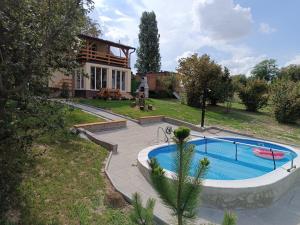 a house with a swimming pool in front of a house at Danube Escape with Jacuzzi, Pool & Spacious Yard by Destination GREEN Croatia in Bogaljevci