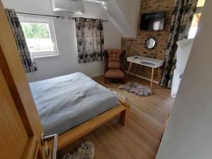 a bedroom with a bed and a desk and a chair at Danube Escape with Jacuzzi, Pool & Spacious Yard by Destination GREEN Croatia in Bogaljevci +13 photos