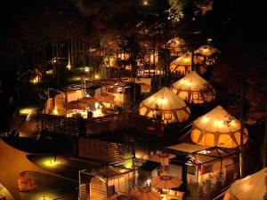 eine Aussicht über ein Restaurant mit Sonnenschirmen in der Nacht in der Unterkunft fabula glamping in Kimitsu