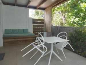 um pátio com uma mesa e cadeiras e um banco em Studio Ti Bambou em La Trinité