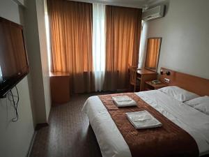 um quarto de hotel com uma cama com dois pratos em Altinnal Hotel em Cocaeli