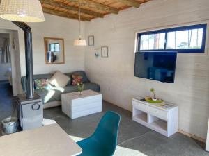 sala de estar con sofá y TV en Mandalas de Mar, en Punta del Diablo