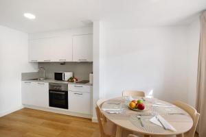 a kitchen with a table with a bowl of fruit on it at Suite Deluxe Puerto Rico B in Puerto Rico de Gran Canaria