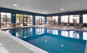 - une grande piscine d'eau bleue dans un bâtiment dans l'établissement Hampton Inn Evansville, à Evansville