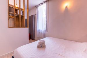 un par de zapatillas sentadas en una cama en un dormitorio en Galerie Mediterranee - Premiere conciergerie, en Montpellier
