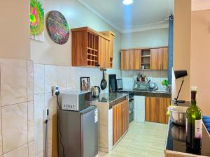 a kitchen with wooden cabinets and a refrigerator at TREAT HOMIES in Kira