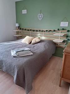 1 dormitorio con 1 cama grande y cabecero de madera en Gite des falaises de Longues 8personnes, en Longues-sur-Mer