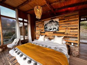 1 dormitorio con 1 cama en una cabaña de madera en Alto Castillo, en Villa Cerro Castillo
