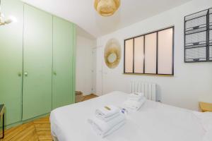 1 dormitorio con 1 cama blanca y armarios verdes en Chic Parisian Retreat - Porte de Montreuil - 2, en París