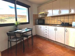 a kitchen with a table and chairs and a window at Apartamento Guanapay by Vulcano Homes in Teguise