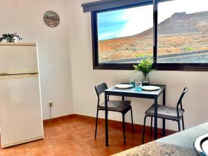 a small table and chairs in a room with a window at Apartamento Guanapay by Vulcano Homes in Teguise +2 photos