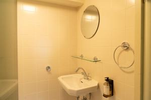 a white bathroom with a sink and a mirror at hotel calisto in Amsterdam +26 photos