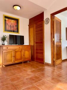 a living room with a television on a wooden cabinet at Apartamento Guanapay by Vulcano Homes in Teguise
