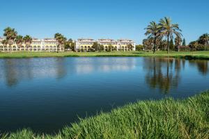 un grand lac en face d'un grand bâtiment dans l'établissement Barceló Costa Ballena Golf & Spa, à Costa Ballena