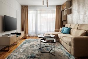 ein Wohnzimmer mit einem Sofa und einem Tisch in der Unterkunft Cosmopolit Booking in Braşov