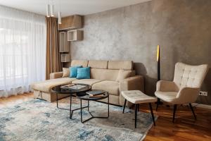 a living room with a couch and a table and chairs at Cosmopolit Booking in Braşov