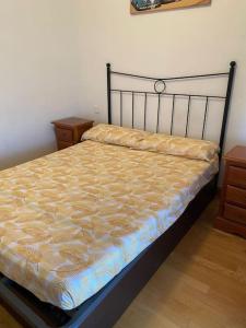 a bedroom with a bed with a yellow comforter at Casa con piscina in Madrid