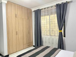 Schlafzimmer mit einem Bett und einem Fenster mit Vorhängen in der Unterkunft TREAT HOMIES in Kira