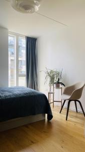 - une chambre avec un lit, une chaise et une fenêtre dans l'établissement ApartmentInCopenhagen Apartment 1574, à Copenhague