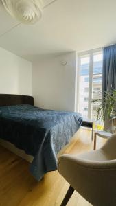 sypialnia z łóżkiem, krzesłem i oknem w obiekcie ApartmentInCopenhagen Apartment 1574 w Kopenhadze