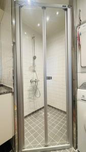 La salle de bains est pourvue d'une douche avec une porte en verre. dans l'établissement ApartmentInCopenhagen Apartment 1574, à Copenhague
