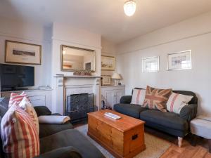 a living room with two couches and a fireplace at 3 Albion Cottages in Southwold