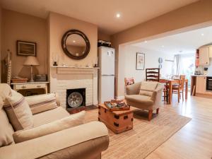 ein Wohnzimmer mit einem Sofa und einem Kamin in der Unterkunft 3 Albion Cottages in Southwold