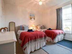 1 Schlafzimmer mit 2 Betten und roten Decken in der Unterkunft 3 Albion Cottages in Southwold