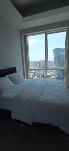een wit bed in een kamer met een groot raam bij Luxury 1+1 bed in NG resident in Istanbul
