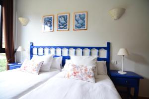 a bedroom with two beds with white sheets and pillows at Apartamentos Los Telares in Hermigua