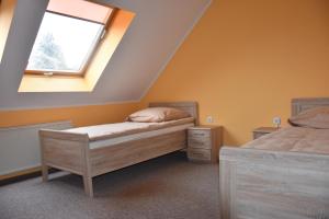 1 dormitorio con 2 camas individuales y ventana en Hotel La-Pergola en Kolkwitz